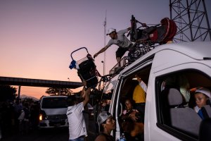 Honduran migrants heading in a caravan to the US, upload their baby strollers on a van, near Pijijiapan, southern Mexico on October 26, 2018. (Credit: Guillermo Arias/AFP/Getty Images)