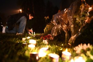 A woman kneels to place a candle outside the Tree of Life Synagogue after a shooting there left 11 people dead in the Squirrel Hill neighborhood of Pittsburgh on Oct. 27, 2018. (Credit: BRENDAN SMIALOWSKI/AFP/Getty Images)