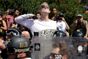 A man makes a slashing motion across his throat toward counter-protesters as he marches with other white nationalists, neo-Nazis and members of the "alt-right" during the "Unite the Right" rally on Aug. 12, 2017 in Charlottesville, Virginia. (Credit: Chip Somodevilla/Getty Images)