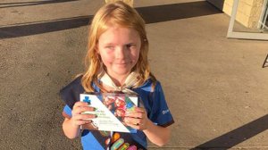 Elina Childs is seen holding a box of Girl Scout cookies.(Credit: Seann Childs via CNN Wire)