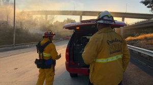 Firefighters work to extinguish a 2-acre brush fire along the 210 Freeway in Pasadena on Oct. 20, 2018. (Credit: Pasadena Fire Department)