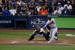 Yasiel Puig #66 of the Los Angeles Dodgers hits a three run home run against Jeremy Jeffress #32 of the Milwaukee Brewers during the sixth inning in Game Seven of the National League Championship Series at Miller Park on October 20, 2018 in Milwaukee, Wisconsin. (Credit: Dylan Buell/Getty Images)