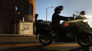 An LAPD motorcycle officer rides past Congregation Bais Yehuda on Nov. 26, 2018 in West Los Angeles. (Credit: Christina House / Los Angeles Times)