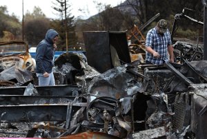 Noah Fisher (R) and Dusty Cope (L) and look through the remains of their home that was destroyed by the Camp Fire on November 22, 2018 in Paradise, California. (Credit: Justin Sullivan/Getty Images)