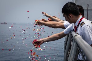 Colleagues of victims of Lion Air flight JT 610 throw flowers from the deck of an Indonesian Navy ship during a visit to the site of the crash on Nov. 6, 2018. (Credit: Ulet Ifansasti / Getty Images)