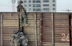 U.S. Marines place barbed wire atop fencing along the U.S.-Mexico border in San Ysidro, California, on Nov. 9, 2018. (Credit: SANDY HUFFAKER/AFP/Getty Images)