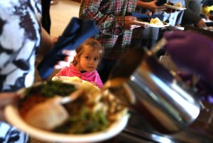 A young Camp Fire evacuee waits in line to receive a free Thanksgiving meal at Sierra Nevada Brewery on Nov. 22, 2018 in Chico. (Credit: Justin Sullivan/Getty Images)