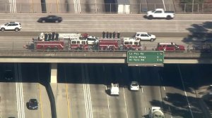 Fire trucks line a freeway overpass during a procession for Costa Mesa Fire and Rescue Capt. Mike Kreza from Mission Viejo to Santa Ana on Nov. 5, 2018. (Credit: KTLA) 