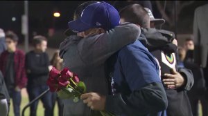 Jason Coffman hands out roses on Nov. 13, 2018, to families during a vigil for the victims of the Thousand Oaks mass shooting. (Credit: KTLA)