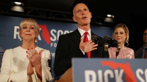 Florida Gov. Rick Scott speaks as he stands with his wife, Ann Scott (left), and daughter Alison Guimard (right) during his election night party on Nov. 6, 2018, in Naples, Florida. (Credit: Joe Raedle/Getty Images)