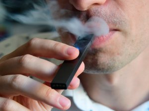 An illustration shows a man exhaling smoke from an electronic cigarette in Washington, DC on October 2, 2018.(Credit: EVA HAMBACH/AFP/Getty Images)