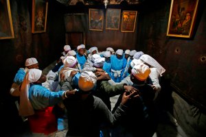 Nigerian pilgrims pray inside the Grotto, believed to be the exact spot where Jesus Christ was born, at the Church of the Nativity in the biblical West Bank city of Bethlehem, on Dec. 24, 2018, on the eve of the Christmas celebration. (Credit: MUSA AL SHAER/AFP/Getty Images)