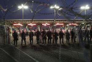U.S. Customs and Border Protection (CBP), officers block the Otay Mesa port of entry from Mexico into the United States early on December 1, 2018 as seen from Tijuana, Mexico. CPB officers staged the crowd control training exercise, using riot gear and fake tear gas, in advance of a potential attempt by members of the migrant caravan to rush the border crossing. (Credit: John Moore/Getty Images)