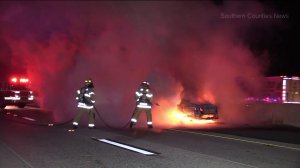 A car burst into flames after the driver hit the center divider while driving the wrong way on the 91 Freeway. (Credit: Southern Counties News)