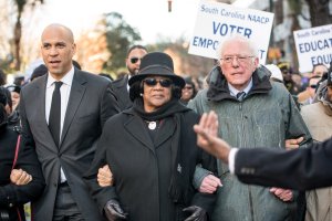 U.S. Sen. Bernie Sanders (I-VT), right, president of the South Carolina NAACP chapter, Brenda Murphy, center, and Sen. Cory Booker (D-NJ) march to the Statehouse in commemoration of Martin Luther King Jr. Day on Jan. 21, 2019, in Columbia, South Carolina. (Credit: Sean Rayford/Getty Images)