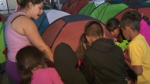 Migrant children gather around as donations are brought into a shelter in Tijuana in January 2019. (Credit: KTLA)
