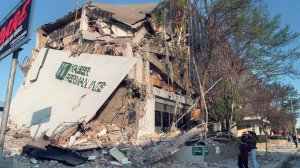 People survey the damage to the Kaiser Permanente Building following the Northridge earthquake on January 17, 1994. (Credit: HAL GARB/AFP/Getty Images)