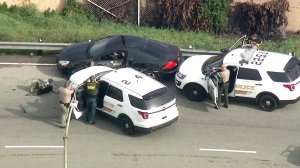 Authorities have guns drawn after a pursuit ends near the 60 Freeway on Jan. 18, 2019. (Credit: KTLA)