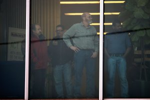 Workers look out an office window following a shooting at the Henry Pratt Co. plant in Aurora, Illinois, on Feb. 15, 2019. (Credit: Scott Olson / Getty Images)