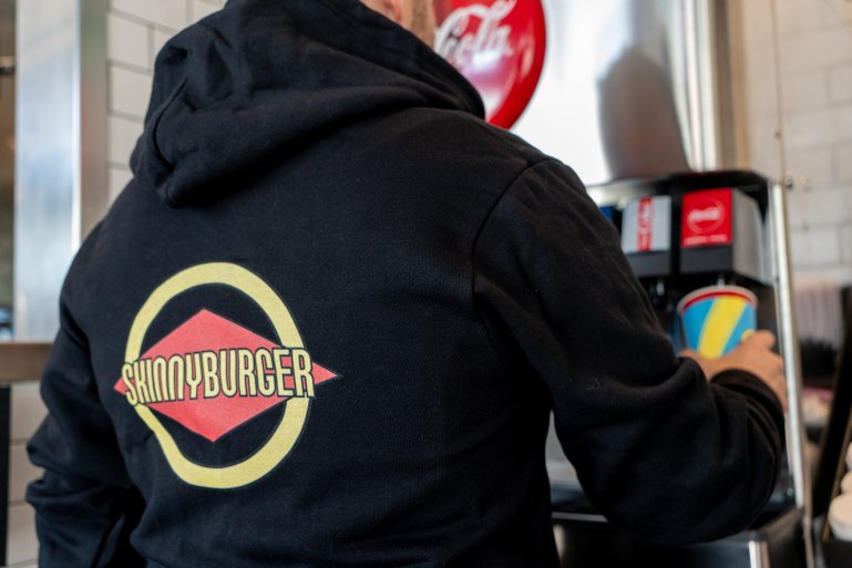 A customer wears a Skinnyburger branded sweatshirt at the chain formerly known as Fatburger in an image provided by the company.