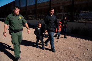 A family from El Salvador walks with a Border Patrol agent after crossing the Rio Grande to claim asylum in El Paso, Texas, on March 19, 2019. (Credit: Paul Ratje / AFP / Getty Images)