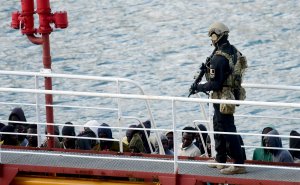 An armed policeman stands guard after migrants disembarked from the Motor Tanker El Hiblu 1 that was hijacked by migrants in Valletta's Grand Harbour on March 28, 2019. (Credit: JONATHAN BORG/AFP/Getty Images)