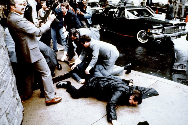 This photo taken by presidential photographer Mike Evens on March 30, 1981, shows police and Secret Service agents reacting during the assassination attempt on then-President Ronald Reagan outside the Hilton Hotel in Washington, D.C. (Credit: Mike Evens / AFP / Getty Images)