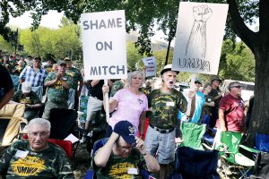 Juanita (L) and Manuel Ojeda of Logan County, West Virginia, hold signs in support of the United Miner Workers of America and in opposition to Senate Majority Leader Mitch McConnell (R-KY) during a UMWA rally on the National Mall September 8, 2016 in Washington, DC. About 100 members of the UMWA were arrested for blocking traffic on Pennslylvania Avenue following the rally to call on Congress to pass the Miners Protection Act. (Credit: Chip Somodevilla/Getty Images)