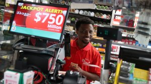 Jackson Mauvais sells Powerball tickets to a customer at the Shell Gateway store on March 26, 2019 in Boynton Beach, Florida. (Credit: Joe Raedle/Getty Images)