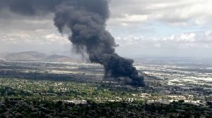 A massive plume of black smoke rises from a fire at a recycling facility in Ontario on April 30, 2019. (Credit: KTLA)