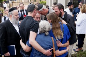 Executive Director Rabbi Yisroel Goldstein (center), who was shot in the hands, hugs his congregants after a press conference outside the Chabad of Poway Synagogue on April 28, 2019. (Credit: SANDY HUFFAKER/AFP/Getty Images)