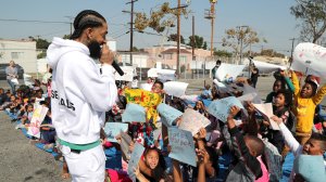 Nipsey Hussle speaks to kids at an event unveiling the basketball courts he helped refurbish at his former elementary school in Hyde Park on Oct. 22, 2018. (Credit: Jerritt Clark/Getty Images for PUMA)