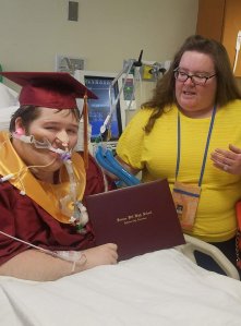 Dakota Johnson holds his diploma in a ceremony his teacher Allison Russell helped put together. (Credit: Carrie Stamper Medley)