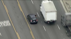 A person is seen pointing a gun at pursuing officers during a chase on May 10, 2019 in Vernon. (Credit: KTLA)