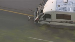 A dog leaps from a moving RV during a pursuit in the San Fernando Valley on May 21, 2019. (Credit: KTLA)