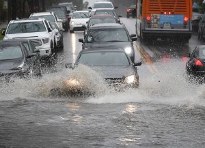 Cars drive through a flooded street after a storm dumped heavy rain on Los Angeles on February 2, 2019, (Credit: MARK RALSTON/AFP/Getty Images)