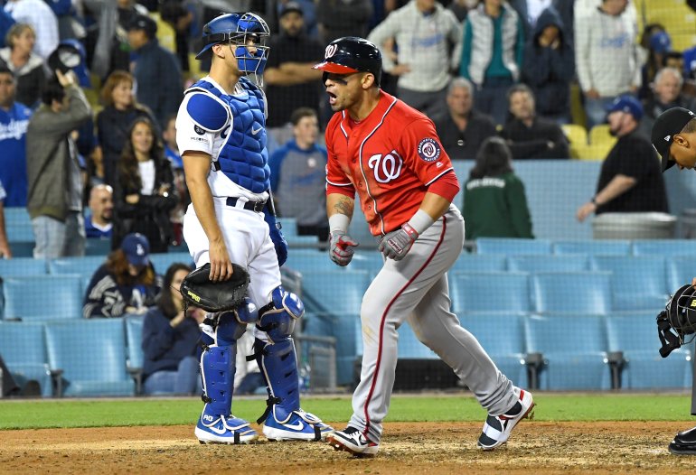 Austin Barnes #15 of the Los Angeles Dodgers looks on as Gerardo Parra #88 of the Washington Nationals celebrates as he crosses the plate after hitting a grand slam home run off Dylan Floro in the eighth inning of the game at Dodger Stadium on May 11, 2019. (Credit: Jayne Kamin-Oncea/Getty Images)