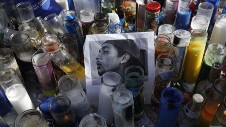 Candles surround a photograph of rapper Nipsey Hussle at a makeshift memorial in this undated photo. (Credit: Los Angeles Times)