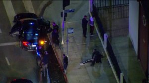 Police take a group of people into custody after several aircraft were struck by laser beams over South Los Angeles on May 16, 2019. (Credit: KTLA)