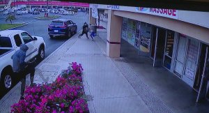 A man is seen on surveillance video snatching the purse of a woman who was later dragged by the suspects' vehicle in Garden Grove on May 8, 2019.