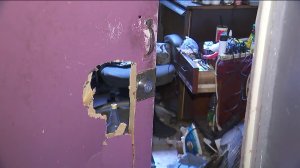 A hole can be seen in the door of one of the building's rooms. (Credit: KTLA)