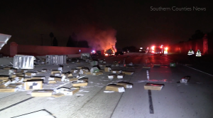 Packages are strewn across the northbound lanes of State Route 22 in Garden Grove as a big-rig burns following a crash on June 9, 2019. (Credit: Southern Counties News)