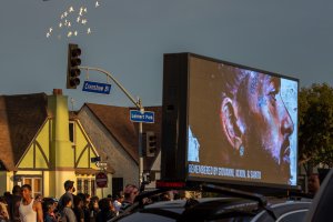 White doves fly near a car with an illuminated picture of slain rapper Nipsey Hussle before the arrival of the funeral procession carrying his body to the Angelus Funeral Home in South Los Angeles on April 11, 2019. (Credit: David McNew / Getty Images)