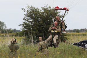 WWII veteran Tom Rice of San Diego, front, lands as he takes part in a parachute drop over Carentan, Normandy, on June 5, 2019, as part of D-Day commemorations marking the 75th anniversary of the World War II Allied landings in Normandy. (Credit: Ludovic Marin / AFP / Getty Images)