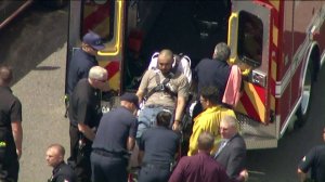 Officers take a man suspected of killing at least three people into custody on July 25, 2019, in Canoga Park. (Credit: KTLA)