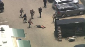 Office surround the driver after apparently tasing him at a Venice Beach Board Walk parking lot following a pursuit on July 12, 2019. (Credit: KTLA)