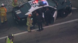 A person who led authorities on a pursuit sits inside a police vehicle after officers took him into custody in Alhambra on Aug. 12, 2019. (Credit: Sky5)