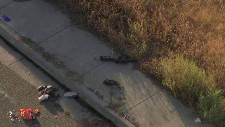 A firearm is seen on the ground at the scene of a shooting that left one CHP officer dead and two other wounded in Riverside on Aug. 12, 2019. (Credit: KTLA)