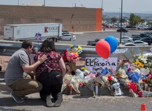People pray beside a makeshift memorial outside the Cielo Vista Mall Wal-Mart where a shooting left 20 people dead in El Paso, Texas, on Aug. 4, 2019. (Credit: MARK RALSTON/AFP/Getty Images)