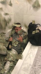 Sitting a tub filled with bills of money, 22-year-old Wyatt Pasekis appears in an undated photo released by the U.S. Department of Justice on Aug. 26, 2019. 